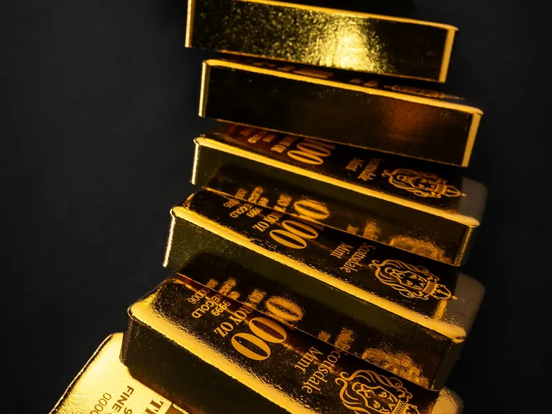 Lingotes de oro apilados sobre superficie oscura